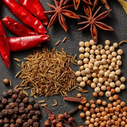 Whole spices including dried red chillies, star anise, cumin, white and black pepper, cloves and coriander seeds