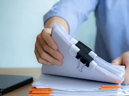 Stack of export documents being sorted at a desk